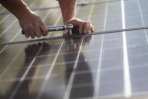Ein Arbeiter installiert Photovoltaikmodule.