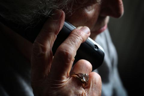 Eine ältere Frau telefoniert mit einem schnurlosen Festnetztelefon.