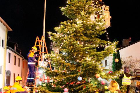 Festlicher Glanz: Die Feuerwehr schmückt den Weihnachtsbaum an der Alten Goldbornschule. © Stadt Flörsheim