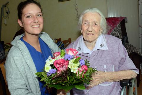 Die jüngste Mitarbeiterin im Heim, Loreen Hinter, überreicht der ältesten Bewohnerin, Elsa Rennert (105), Blumen zum Geburtstag.Foto: wita/Martin Fromme  Foto: wita/Martin Fromme