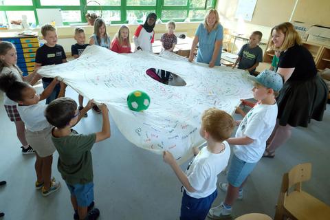 Zum Projekt „Friedensbrücke“ gehört in der Klasse 3a der Wiedbachschule auch ein Tuchspiel. Martin Fromme