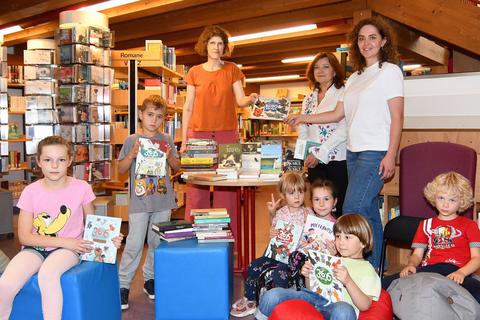 Gemeinsam mit zahlreichen ukrainischen Kindern übergibt die ukrainische Buchautorin Halyna Vdouychenko (hintere Reihe, Zweite von rechts) und Kateryna Shumeyko (rechts) von der Flüchtlingshilfe für die Ukraine eine Spende von rund 50 Büchern an die Leiterin der Idsteiner Stadtbücherei, Claudia Jaeger (links). Stefan Gärth