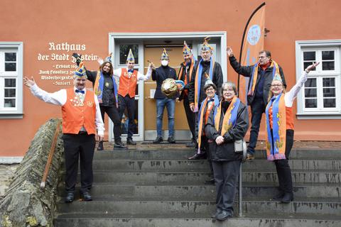In kleiner Runde übergibt Bürgermeister Christian Herfurth (Mitte) symbolisch den Rathausschlüssel an den 1. Vorsitzenden des Karnevalsvereins Idstein, Robin Rütten. Foto: Mallmann/AMP