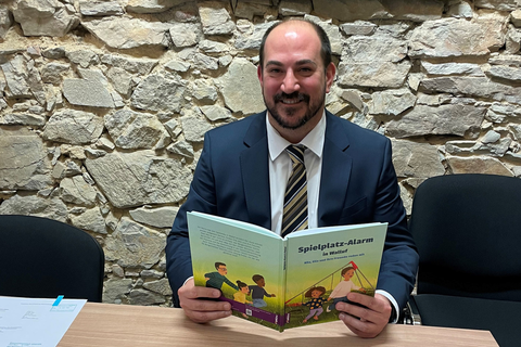 Bürgermeister Nikolaos Stavridis spielt die Hauptrolle im neuen personalisierten Kinderbuch "Spielplatz-Alarm in Walluf". 