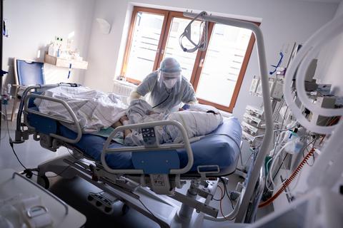 Ein Intensivpfleger kümmert sich um eine an Covid-19 erkrankte Patientin. Symbolfoto: dpa