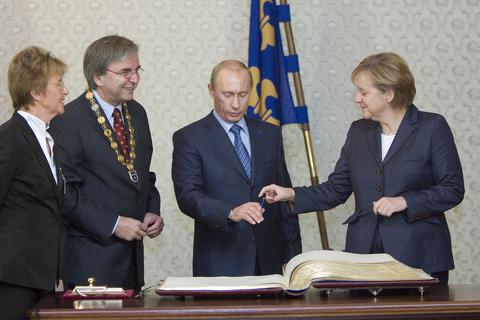 Am 14. Oktober 2007 hat sich der russische Präsident Wladimir Putin zusammen mit Bundeskanzlerin Angela Merkel ins Goldene Buch der Landeshauptstadt Wiesbaden eingetragen. Links im Bild die 2009 verstorbene Stadtverordnetenvorsteherin Angelika Thiels und der Oberbürgermeister Helmut Müller mit seiner Amtskette.