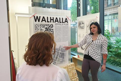 Die Architektur-Studentin Vanessa Klassen (rechts) präsentiert einen der acht Entwürfe zum Wiesbadener Walhalla.              Foto: Hochschule Rhein-Main