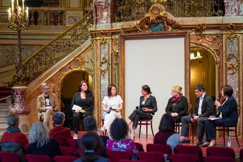 Vertreter dreier mit dem Friedensnobelpreis ausgezeichneter Menschenrechtsorganisationen sitzen auf dem Podium im Staatstheaterfoyer.