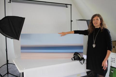 Beate Kupka in ihrem Fotostudio mit einem „Streifen“-Bild. Durch die Bewegung der Kamera mit langer Belichtungszeit entsteht der Eindruck von Weite und Freiheit. Foto: Beate Rasch  Foto: Beate Rasch