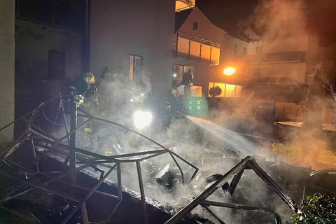 Feuerwehrleute der Wiesbadener Feuerwehr sowie der Freiwilligen Feuerwehr Delkenheim löschen ein Gewächshaus, das in der Delkenheimer Soonwaldstraße in Brand geraten war. 
