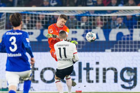 Mit einem Kung-Fut-Tritt streckt der Schalker Alexander Nübel den Frankfurter Gacinovic nieder. Foto: dpa