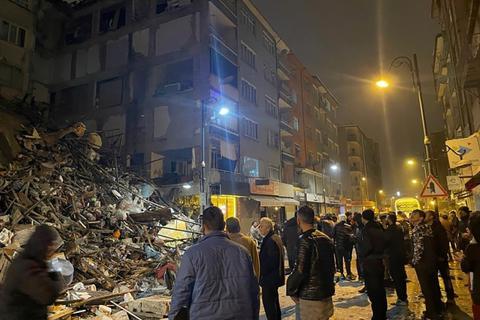 Menschen versammeln sich um ein eingestürztes Gebäude in Pazarcik in der südtürkischen Provinz Kahramanmaras.
