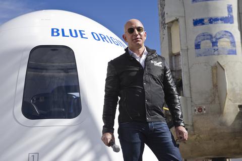 Der Milliardär Jeff Bezos steht vor einer Weltraumkapsel auf dem Space Symposium in Colorado Springs. Bezos und drei weitere Passagiere sind heute (20. Juli) an Bord der New-Shepard-Rakete seiner Firma Blue Origin zum Rand des Weltraums gestartet.  Foto: Chuck Bigger/Space Symposium via ZUMA Wire/dpa