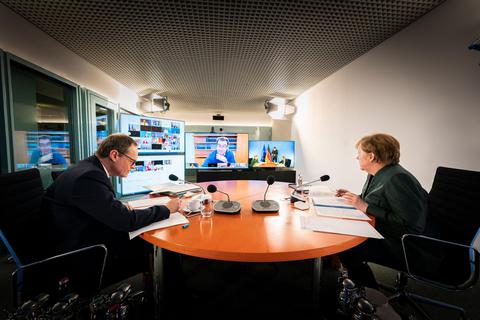 Bundeskanzlerin Angela Merkel (rechts) und Berlins Regierender Bürgermeister Michael Müller beraten im Kanzleramt mit den Ministerpräsidenten der Bundesländer, die via Video zugeschaltet sind. Eigentlich tagt die Runde vertraulich. Doch regelmäßig gelangen Informationen an die Öffentlichkeit – sehr zum Ärger mancher Beteiligter. Foto: dpa