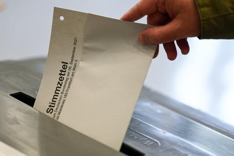 Ein Mann steckt in einem Wahllokal in Frankfurt seinen Stimmzettel für die Bundestagswahl 2021 in eine Wahlurne. Foto: dpa
