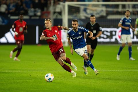 Tymoteusz Puchacz vom 1. FC Kaiserslautern am Ball. Im Hintergrund Thomas Ouwejan vom FC Schalke 04.