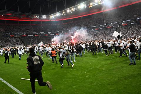 Nach dem Spiel der Eintracht in der Europa League gegen West Ham United laufen die Frankfurter Fans jubelnd über das Spielfeld.  Archivfoto: dpa
