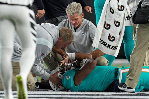 Miami Dolphins-Quarterback Tua Tagovailoa wird auf dem Feld liegend untersucht. Foto: Jeff Dean/AP/dpa
