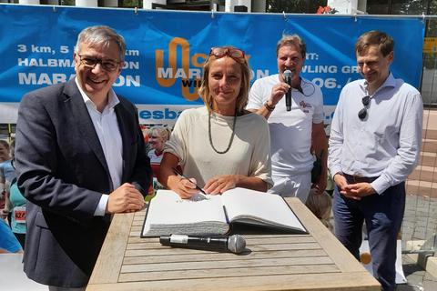 Petra Wassiluk trägt sich im Beisein von Oberbürgermeister Gert-Uwe Mende (links) ins Sportlerehrenbuch der Stadt Wiesbaden ein. Foto: Sporthilfe