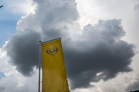 Eine dunkle Wolke schwebt in Rüsselsheim über einem Firmenlogo am Stammsitz von Opel. Archivfoto: dpa