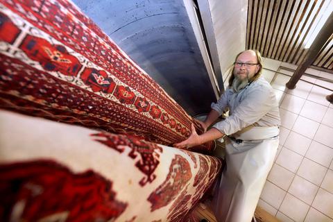 Handarbeit: Firmenchef Ralf Gotzmann steht an der Teppichwellenschleuder und entwässert einen Orientteppich.  Foto: Andreas Kelm 