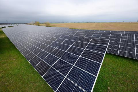 Solaranlagen sind für ein Photovoltaik-Speicher-Kraftwerk auf einer Wiese montiert.